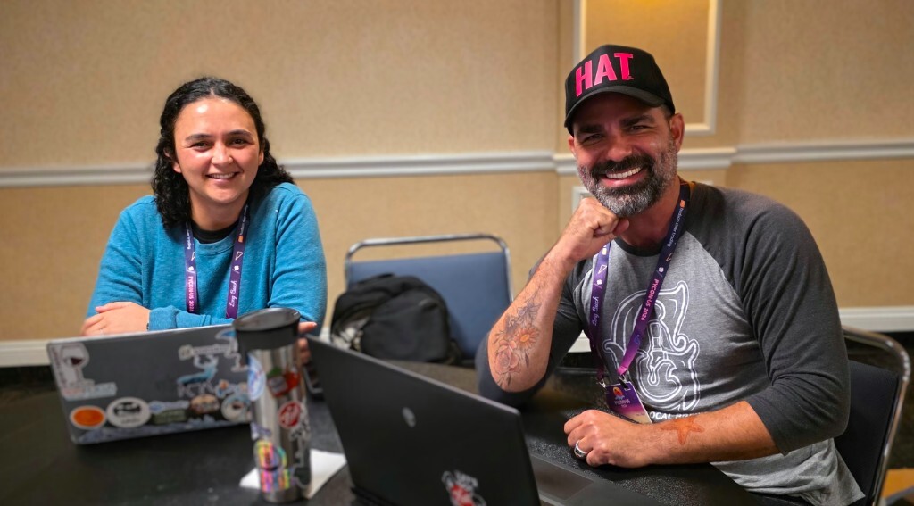 Three pyOpenSci community members smiling together at an outdoor patio during PyCon US 2026 in Long Beach.